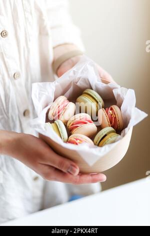 girl confectioner entrepreneur holds a box with macaroons in her hands Stock Photo