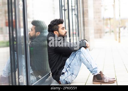 Young Man sitting outside on the bottom Stock Photo