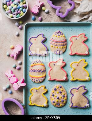 easter cookies shaped like eggs and bunnies on green tray from above. Stock Photo