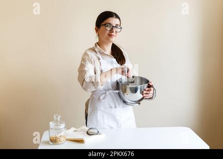 girl confectioner entrepreneur in her kitchen while cooking Stock Photo