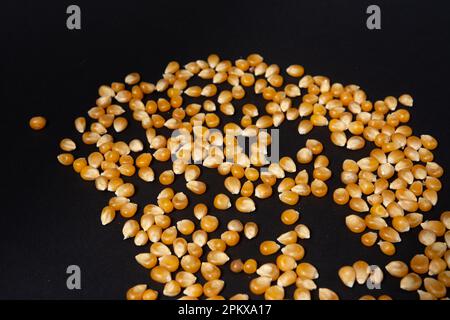 Corn kernels for making popcorn on black background, copy space and top view. Stock Photo