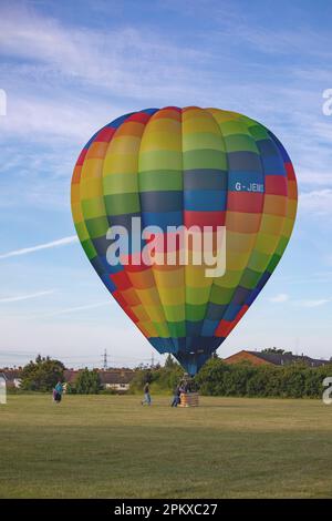 A hot air balloon lands in a park in the suburbs of east London after the Lord Mayor's Balloon Regatta. Stock Photo