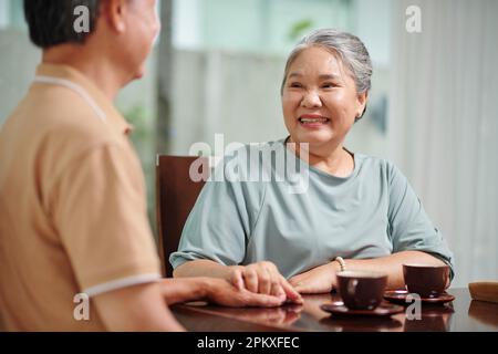 Cheerful senior couple having tea and discussing news Stock Photo