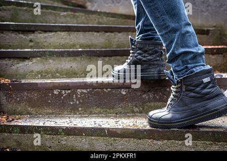 A man in boots on the old steps, close-up. Stock Photo