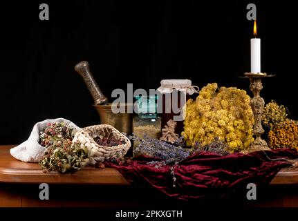mortar and pestle. on a black background. wooden table. Dried healing herbs, flowers and candles, ritual purification , copyspace Close up of healing Stock Photo