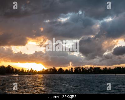 Sunset and dark clouds of passed rain storm - sunshine after the rain on Ketelmeer lake, Flevoland, Netherlands Stock Photo