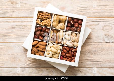 Various varieties of nuts lying in paper box on table background. Top view. Healthy food. Close up, copy space, top view, flat lay. Walnut, pistachios Stock Photo