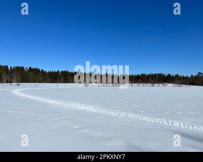 Vast snowy landscape in northern Sweden with a winding path through the snow Stock Photo