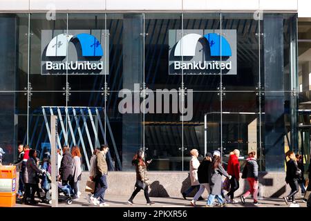People walk past a BankUnited bank branch, 960 6th Ave, New York in Manhattan's Herald Square. Stock Photo