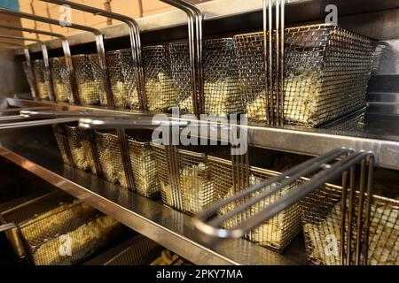 Potatoes ready to be cooked and turned into chips, pictured in a fish and chip shop in Portsmouth, Hampshire, UK. Stock Photo