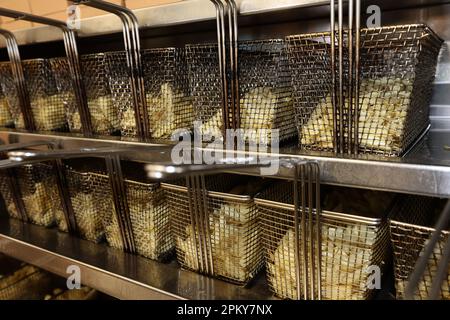 Potatoes ready to be cooked and turned into chips, pictured in a fish and chip shop in Portsmouth, Hampshire, UK. Stock Photo