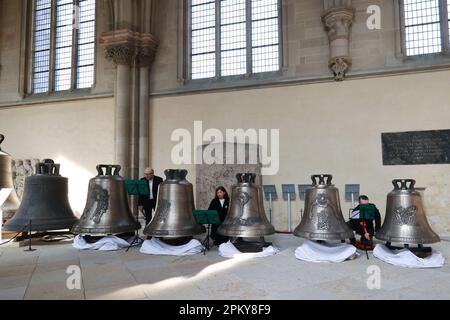 Magdeburg, Germany. 10th Apr, 2023. Musicians strike the five newly cast bells for the Magdeburg Cathedral ringing during a festive service. According to the Cathedral Bell Association, the quintet, cast on February 24 in Neunkirchen (Baden-Württemberg), bears the names 'Cantemus' (let us sing), 'Benedicamus' (let us bless), 'Queramur' (let us lament), 'Resistamus' (let us resist) and 'Dubitemus' (let us doubt). Credit: Peter Gercke/dpa-Zentralbild/dpa/Alamy Live News Stock Photo