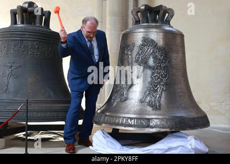 Magdeburg, Germany. 10th Apr, 2023. Reiner Haseloff (CDU), Minister President of Saxony-Anhalt, strikes the first 'Cantemus' bell during a festive service to mark its inauguration. Five newly cast bells for the ringing of Magdeburg Cathedral were presented and inaugurated on Easter Monday. Credit: Peter Gercke/dpa-Zentralbild/dpa/Alamy Live News Stock Photo