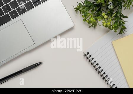 White office desk table with blank notebook, laptop and other office supplies. Top view with copy space. Stock Photo