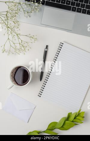 Flat lay, top view office table desk. Workspace with blank clip board, laptop, office supplies, pencil, green leaf, and coffee cup on white background Stock Photo