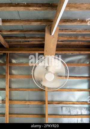 The old orbit fan is hanging on the wooden frame of the pavilion in the garden of the restaurant, front view with the copy space. Stock Photo