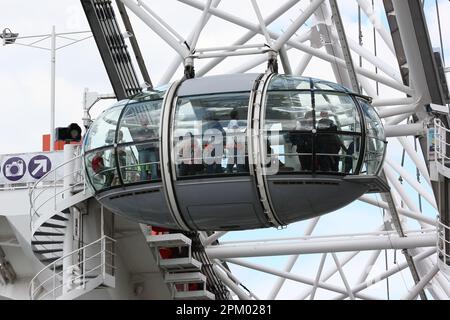 A ferris wheel with people enjoying a ride on it, while taking in the stunning views of the surrounding area Stock Photo