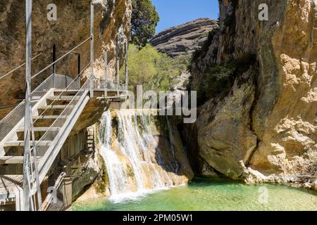 An idyllic waterfall in the Vero river canyon, with light blue water and mountains on the background during a summer day in Alquezar, Spain Stock Photo