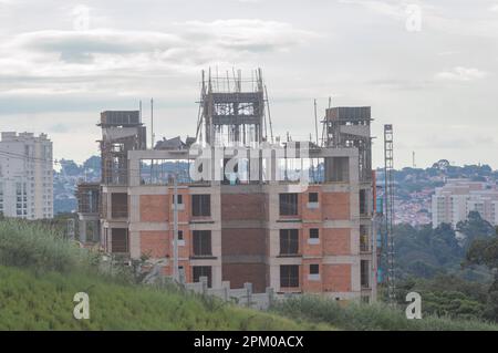 Construction in progress with grass around the landscape of a city in the background. Stock Photo