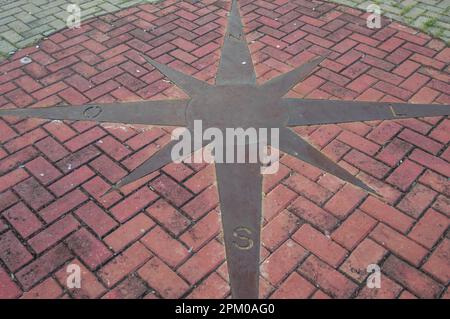 compass into the floor,compass showing direction signs. Stock Photo