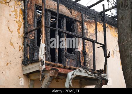 Facade of an old house after a fire. Burnt residential building balcony. Exterior of destroyed house. Stock Photo