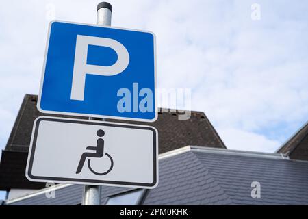 Blue and white parking sign with wheelchair for drivers with disabilities Stock Photo