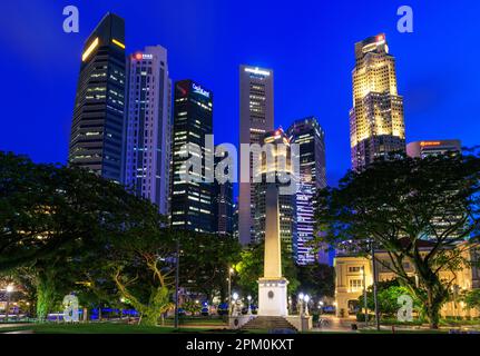 Dalhousie Obelisk and city skyline at dusk, Empress Lawn, Singapore Stock Photo