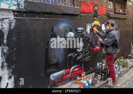 Street artist working at Hosier Lane. This street  in Melbourne, Australia is famous for its street art and graffiti. Stock Photo