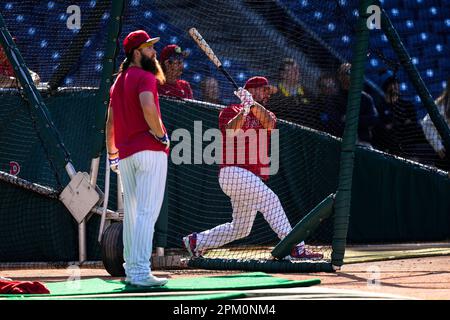 Philadelphia Phillies - Brandon Marsh looking excited, while holding the  end of a baseball bat in his right hand. He is wearing batting gloves, a  long sleeve red shirt, a red hat