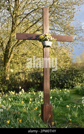 Easter Cross at St Andrews Church, Great Linford, Milton Keynes with daffodils. Stock Photo