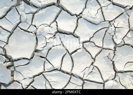 Texture, background of dry cracked earth ground. Deep cracks in land as symbol of hot climate and drought. Global shortage of water on planet. Concept Stock Photo