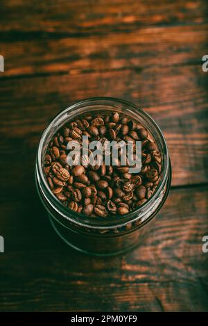 Jar Full of Fresh Roasted Coffee Beans on Wooden Table Stock Photo