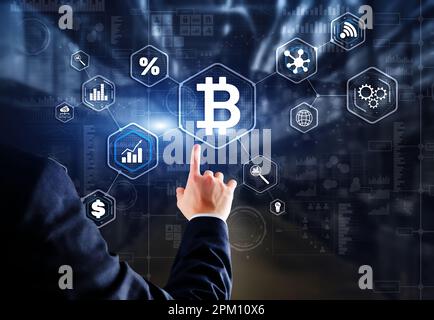 Man clicks on a virtual screen bitcoin icon. Stock Photo