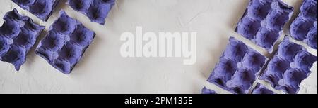 Top view of empty egg cartons, of blue-purple colors, to recycle, on white background, egg boxes Stock Photo