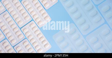 Pharmaceutical medication and medicine pills in packs on blue background. White pills in blister packs. Healthcare and medicine concept Stock Photo