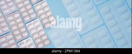 Pharmaceutical medication and medicine pills in packs on blue background. White pills in blister packs. Healthcare and medicine concept Stock Photo