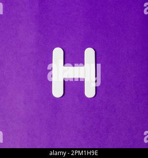 Uppercase letter H - wood texture - Purple background Stock Photo