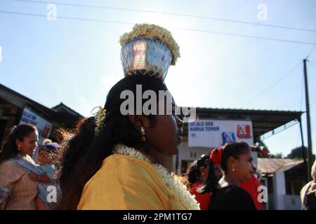 Deliserdang, Indonesia. 09th Mar, 2023. A Hindu woman from the ethnic Tamils, seen with a mouth piercing carrying a jug filled with cow's milk, held high above her head, as she walks towards the Sri Kartigay Sibolangit temple. Ethnic Tamil women, celebrate an annual festival in the month of Pangguni or Pangguni Uthiram to worship the god Muruga. (Photo by Kartik Byma/SOPA Images/Sipa USA) Credit: Sipa USA/Alamy Live News Stock Photo