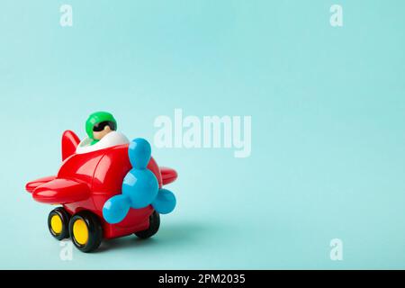 Plastic toy plane on blue background. Top view Stock Photo