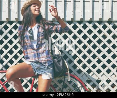 Why walk when youve got wheels. a beautiful young woman riding her bike in the park. Stock Photo