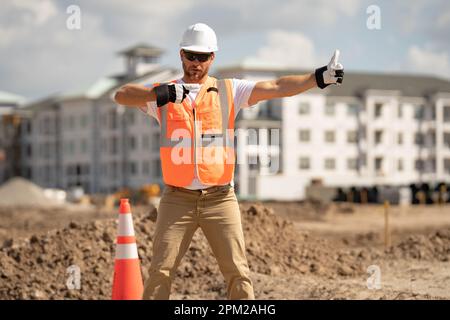 Builder in helmet on construction site. Construction engineer worker in builder uniform on construction. Portrait of builder ready to build new house Stock Photo