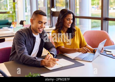 Multi-Cultural Business Colleagues Meeting Around Laptop In Modern Office Stock Photo