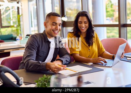 Multi-Cultural Business Colleagues Meeting Around Laptop In Modern Office Stock Photo