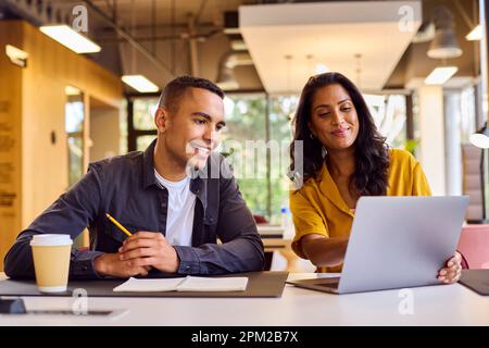 Multi-Cultural Business Colleagues Meeting Around Laptop In Modern Office Stock Photo
