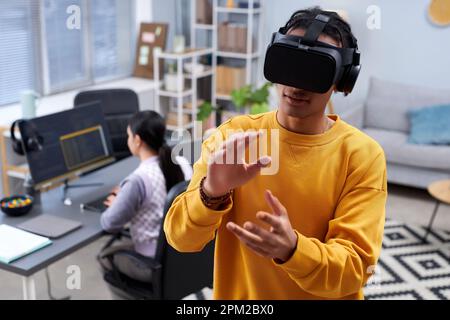 Waist up portrait of black young man using VR in IT development office and gesturing, copy space Stock Photo
