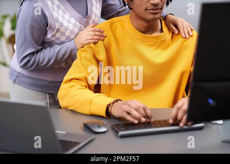 Close up of two young people reviewing code together in IT development office and using computer, copy space Stock Photo