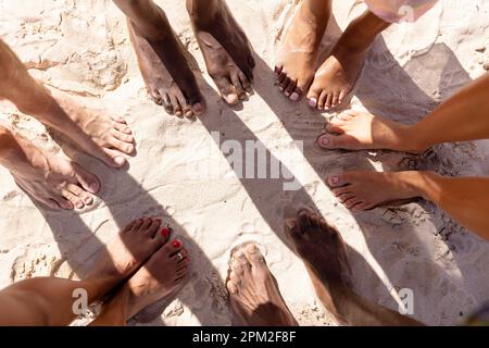 Close up of diverse friends feet at beach Stock Photo
