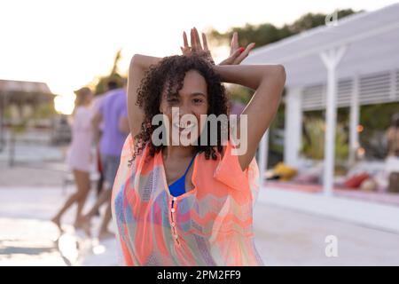 Portrait of happy african american woman dancing and smiling at beach Stock Photo