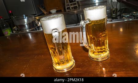 Jar of Beer on a White Wooden Board at a Public Bar Stock Photo
