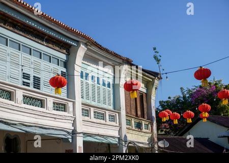 A series of red Chinese lanterns hung on a line with a vintage building in the background Stock Photo